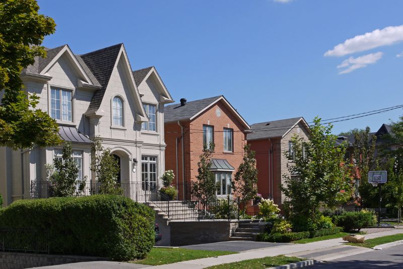 Manicured front-yard hedges and garden beds along a suburban street