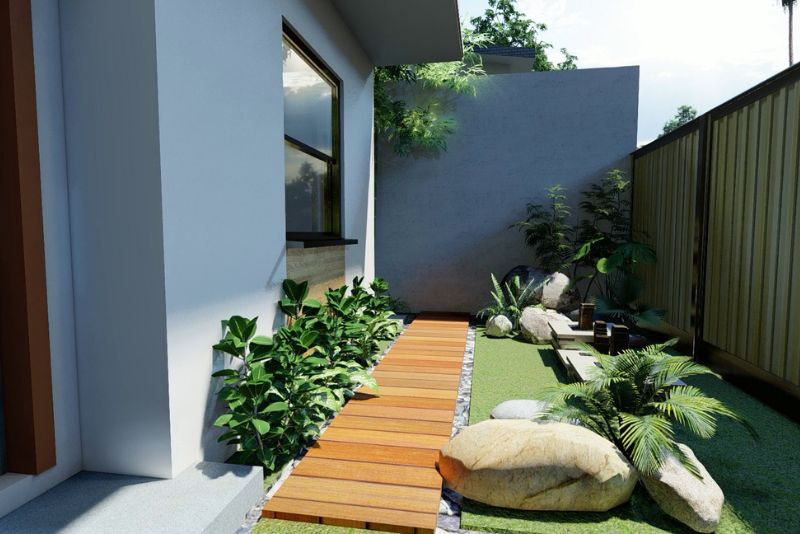 Narrow side yard landscaped with a timber boardwalk path, native plantings and feature rocks